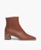 Side view: Coclico Juju Boot in Caramello leather, a minimalist boot featuring an inside zip closure, soft squared-off toe, mid-height solid wood block heel, mid-height shaft. 1