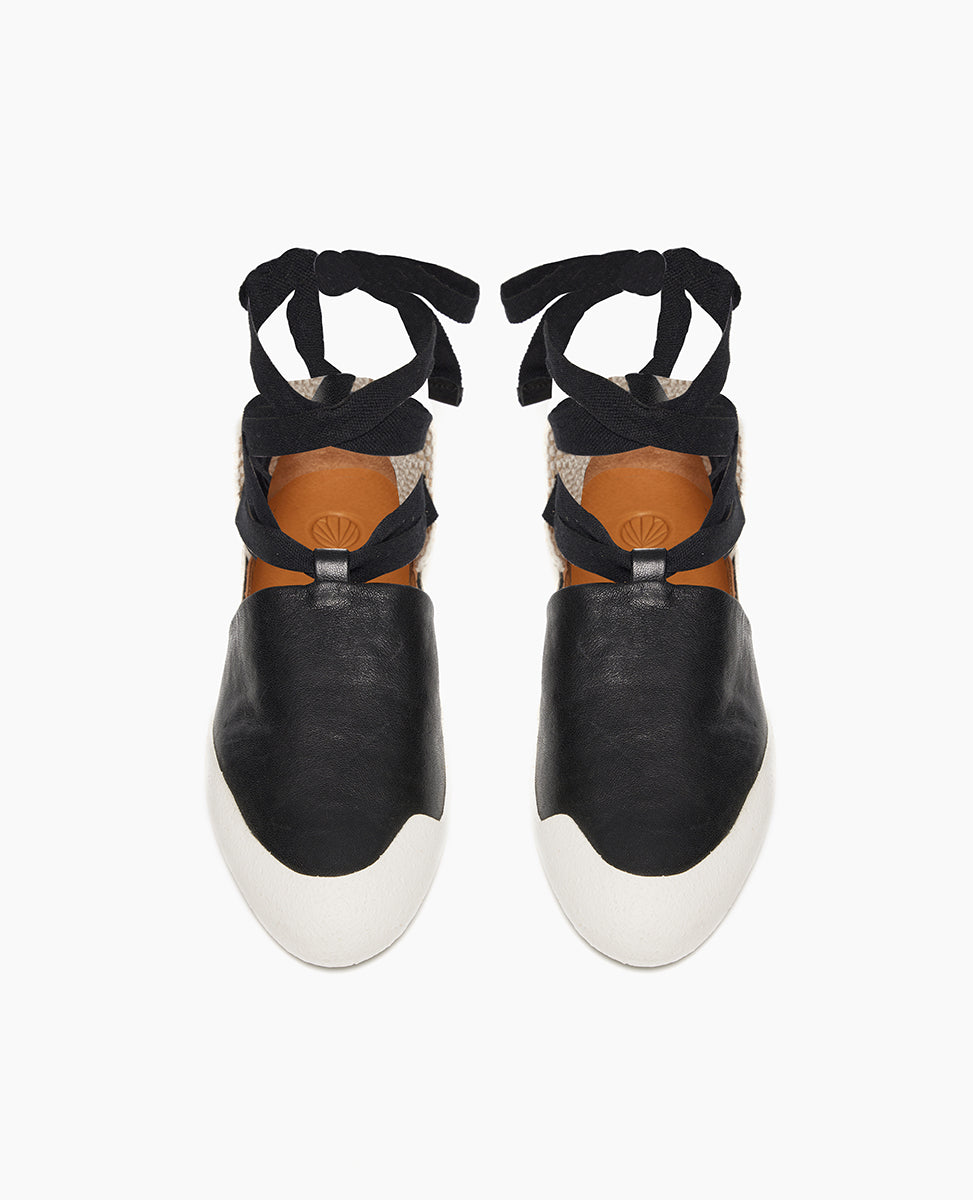 Top view: Coclico Kashm Sneaker in Black leather, a unique flat-like feel sneaker with recycled rubber sole, leather upper secured with wide cotton laces that wind around the ankle.