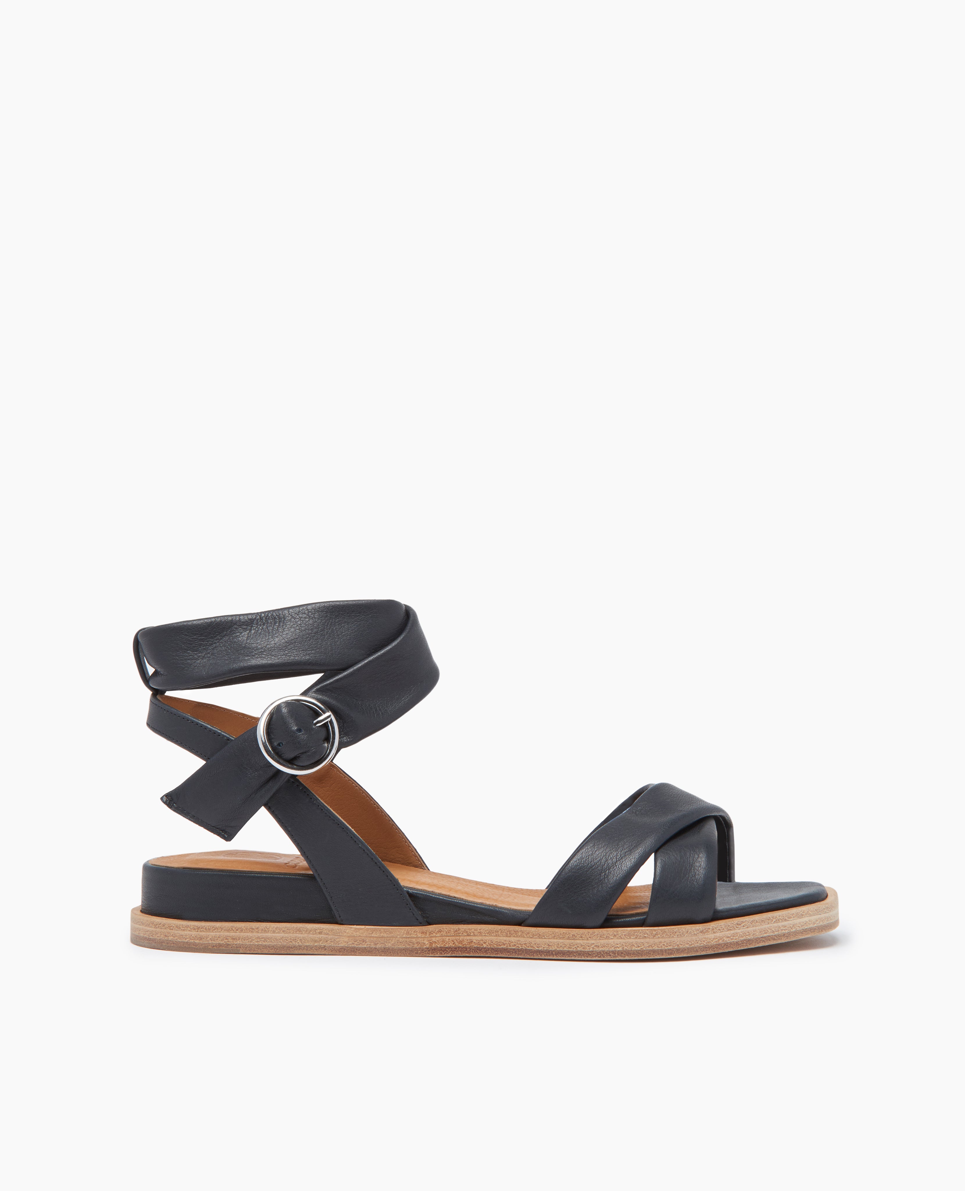 Side view of Coclico Katriane Sandal in Deep Sea leather: open sandal with tubular straps across foot and ankle, buckle closure, slight leather wrapped wedge.