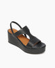 Angled view of Coclico Lion Wedge in Deep Sea (blue/black) leather, a full coverage t-strap wedge with elasticized leather slingback strap with a leather wrapped cork platform. 2