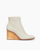 Side view of the Coclico Lodi Boot in Greige leather, a solid-wood, sculpted, inset 75mm height wedge with inside zip closure, seam detail on top of foot and rounded toe. 1