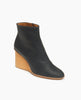 Coclico Lodi Boot in Black leather, angle view: Solid-wood, sculpted, inset 75mm height wedge with inside zip closure, seam detail on top of foot and rounded toe. 4