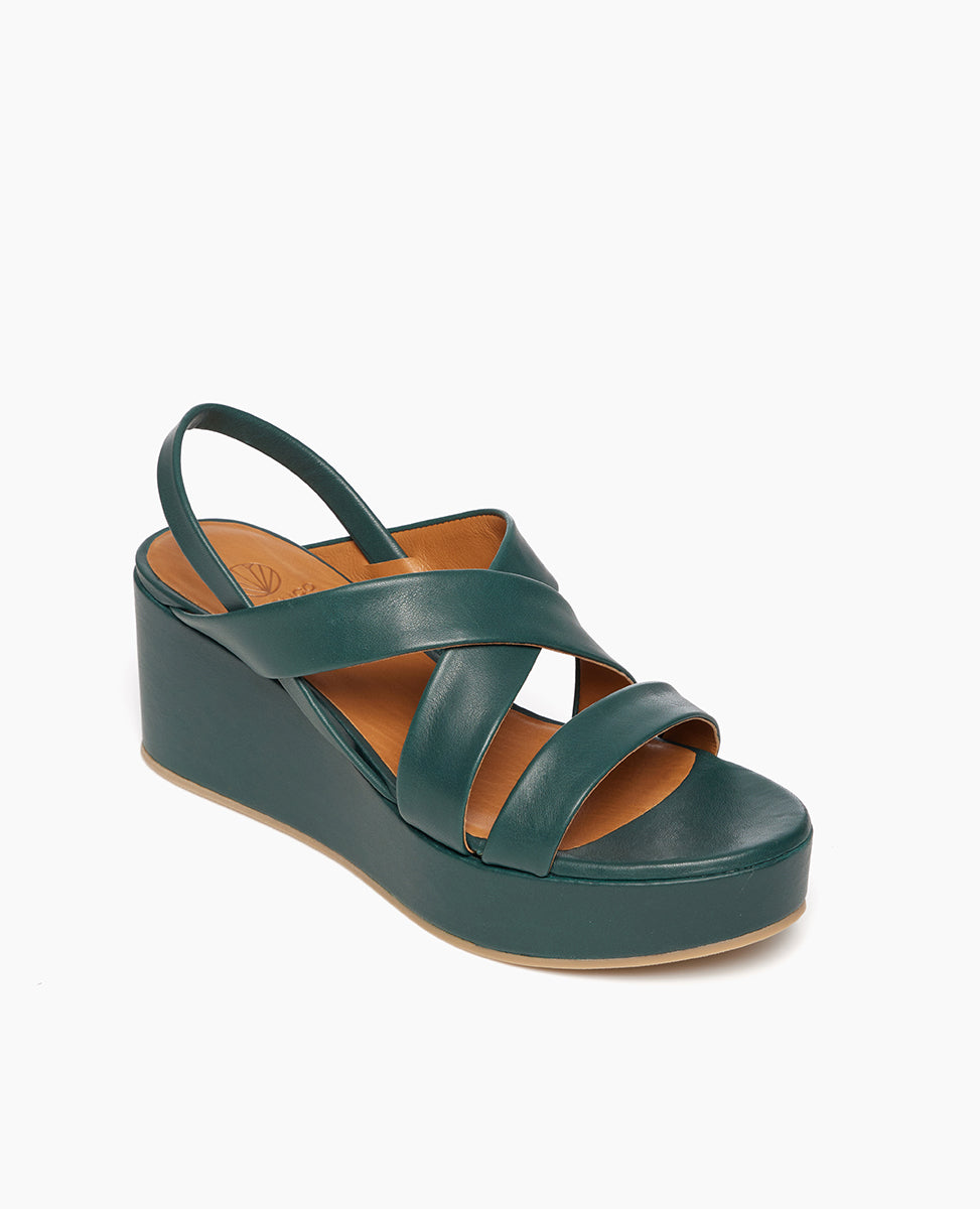 Coclico Lylo Wedge in Riviera Green leather, angle view: leather wrapped cork wedge, elasticated slingback strap, crisscrossed straps across foot.