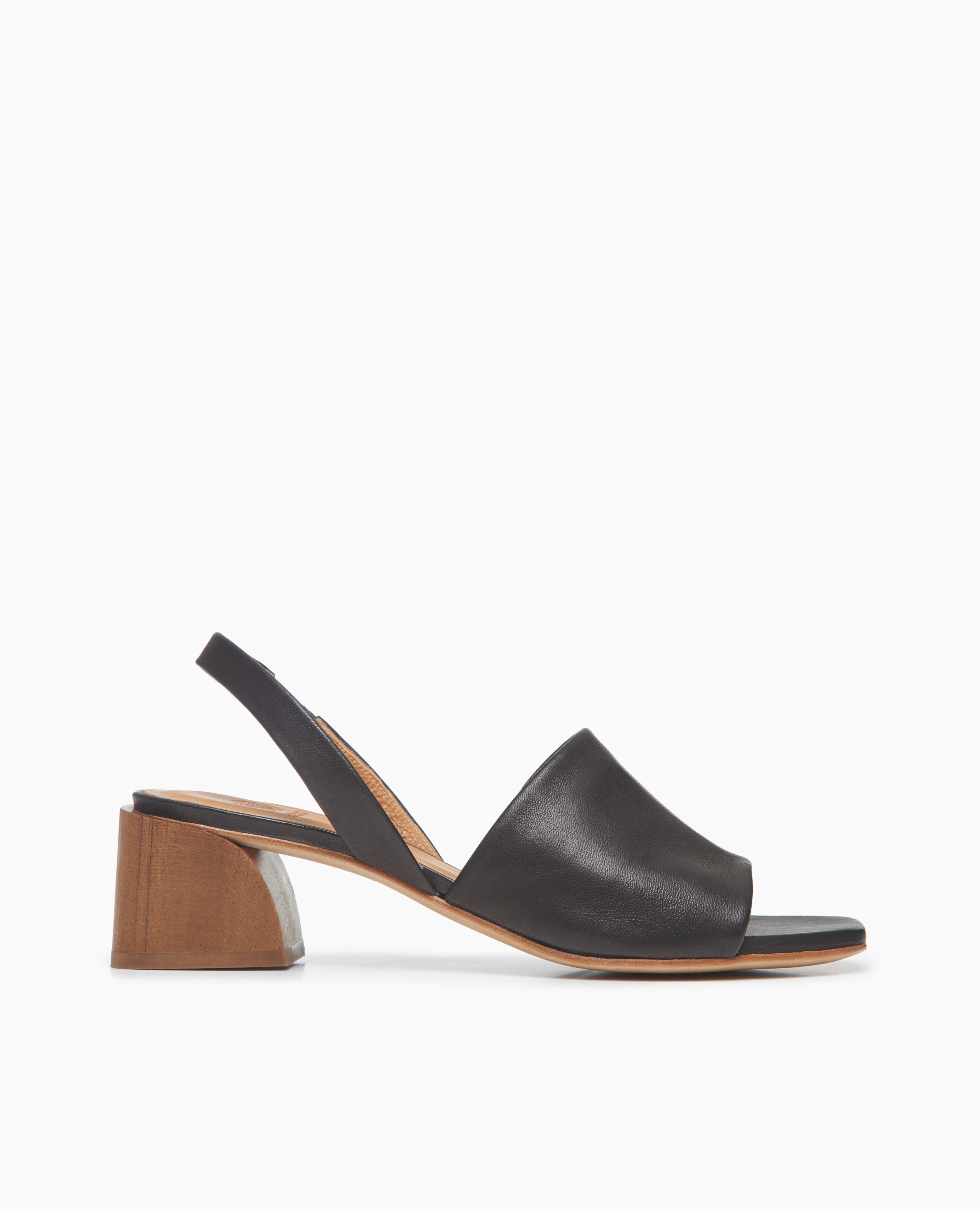 Side view: Coclico Okolo Sandal in Black leather a slingback sandal with wide stretch leather band across the foot and softly curved, low, solid wood heel.