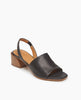 Coclico Okolo Sandal in Black leather, angled view: slingback sandal with wide stretch leather band across the foot and softly curved, low, solid wood heel. 2