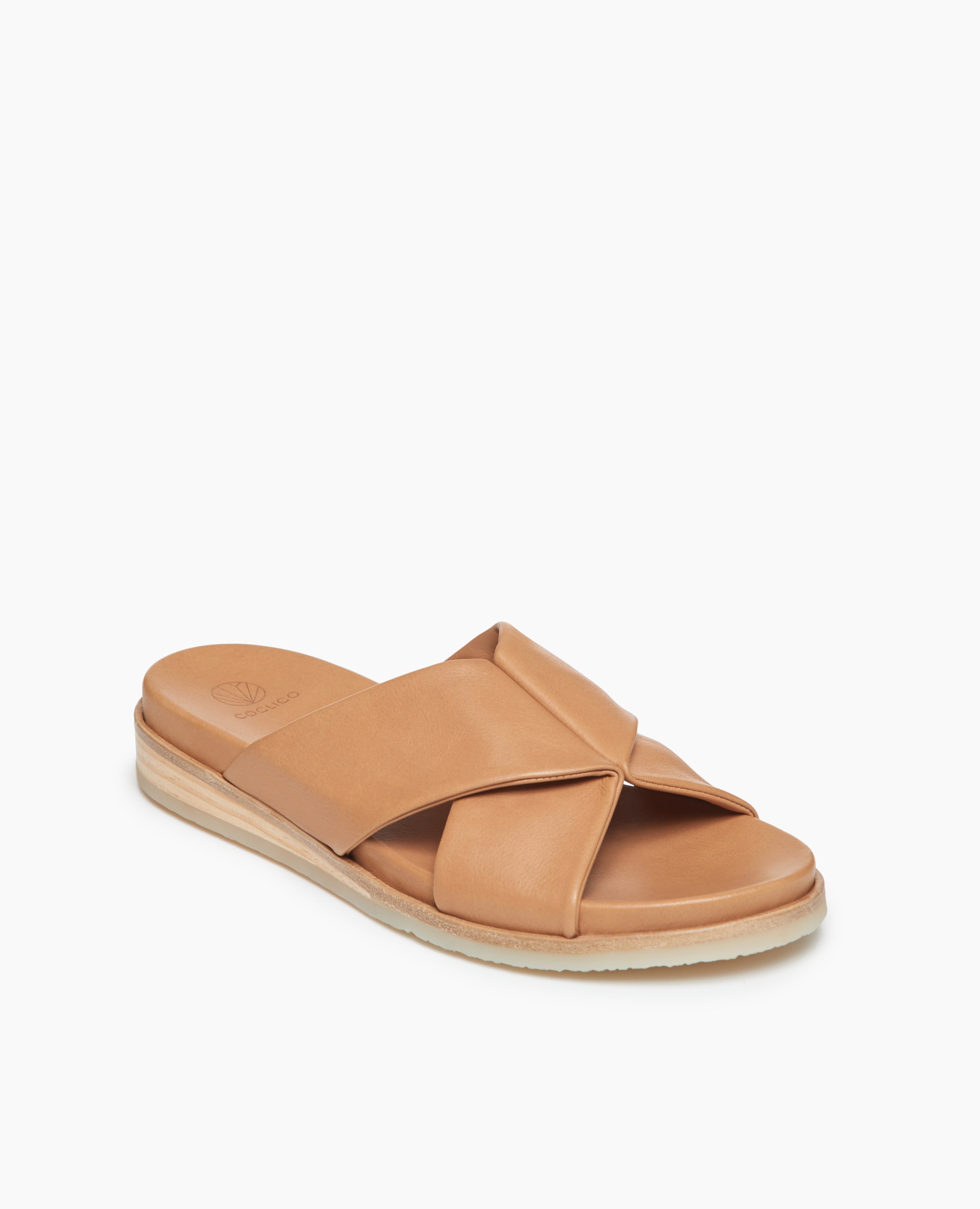Coclico Pasque Sandal in Mandorla leather:angle view of a low pine wedge slide sandal with gum-rubber sole and intertwined leather tube straps across foot.