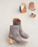 Coclico Pimiento Boot in Anthracite suede - side view of boot in sunlight with wood art decor in background.  2