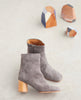 Coclico Pimiento Boot in Anthracite suede - side view of boot in sunlight with wood art decor in background. 2