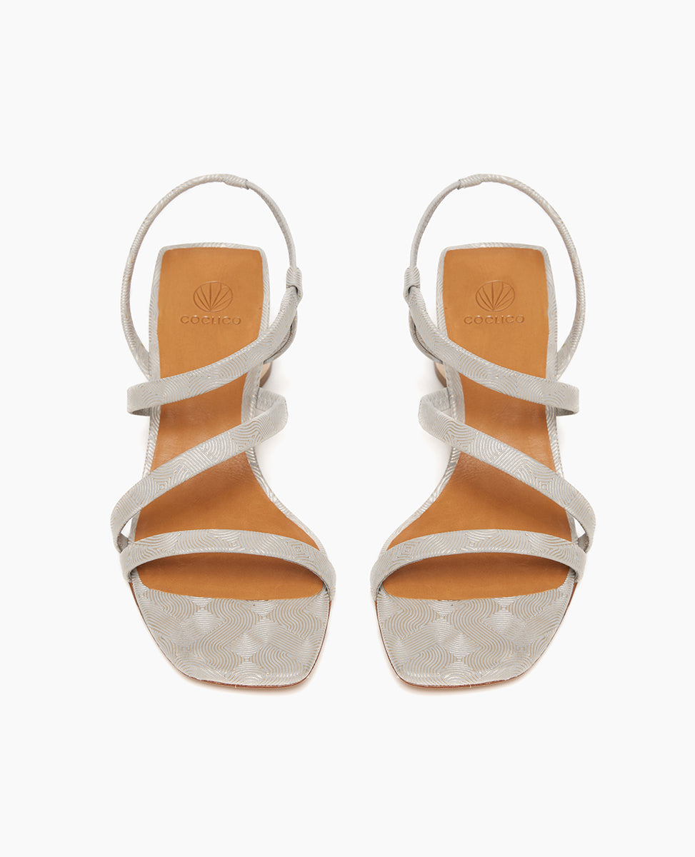 Coclico Shirin Heel in Platino Emboss (textured) leather, top view: Open sandal with asymmetrical string-like straps across foot, solid mid-height wood heel.