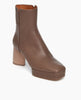 Angled view of the Travis Boot in Taupe: features a formed squared toe and balanced with a platform. Inside zip closure. 2