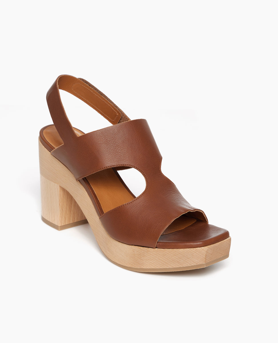 Angle view: Coclico Vicky Clog in Caramello leather a t-straped clog with arched openings, angular toe, round heel and tall-height solid wood base.