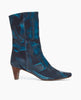 Side view of the Wakame Boot in Painter's Blue split suede: a sophisticated snip-point-toe boot with an arched wood heel. Inside zip closure. 1