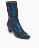 Angled view of the Wakame Boot in Painter's Blue split suede: a sophisticated snip-point-toe boot with an arched wood heel. Inside zip closure. 3
