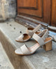 Close up, side view shot of the Coclico Bita Heel in Grey Mist on the stone steps of a building in France. 2