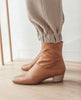 Sunlit side view, close up of Coclico Caviar Boot in Mandorla leather: simple & modern boot with a low-height wood block heel, inside zip closure and tall shaft height. 6