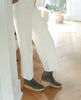 Model in a crepe-soled wedge with a .5 inch height, leather welt, natural soft wrinkles and a patinated metal back zipper closure - Coclico Hop Boot in Anthracite suede. 6