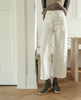 Woman standing & posing in the Coclico Hop Boot in Anthracite suede, a crepe-soled wedge with a .5 inch height, leather welt, natural soft wrinkles and a patinated metal back zipper closure. 7