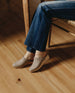 Woman seated modeling the Coclico Milk Clog in Limestone nubuck.  4