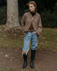 Outdoor shot of woman wearing a modern pull-on riding boot with seam detailing around ankle, classic toe shape and solid wood heel - Coclico Mine Boot in Black leather. 5