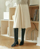 Model wearing the Coclico Mine Boot in Black leather, a modern pull-on riding boot with seam detailing around ankle, classic toe shape and solid wood heel - home decor in background. 3