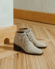 Sunlit, close up side view shot of the Coclico Sake Boot in Siberia (cream) cord suede - on wood flooring. 4