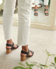 Model showing off Coclico Bita Heel in Deep Sea leather's elasticated back strap and gently curved wood block mid-height heel. 7