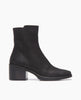 Side view of the Coclico Franna Boot in Black leather: a mid-height solid wood block black heel, stepped topline, squared-off toe, scored rubber sole and an inside zip closure. 1