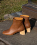 Pair of the Ione Boot in Caramello pictured outside on a stone slab with grass behind.  2