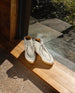 Front angled view of the Coclico Quinn Boot in Griege placed on a wooden window sill.  2