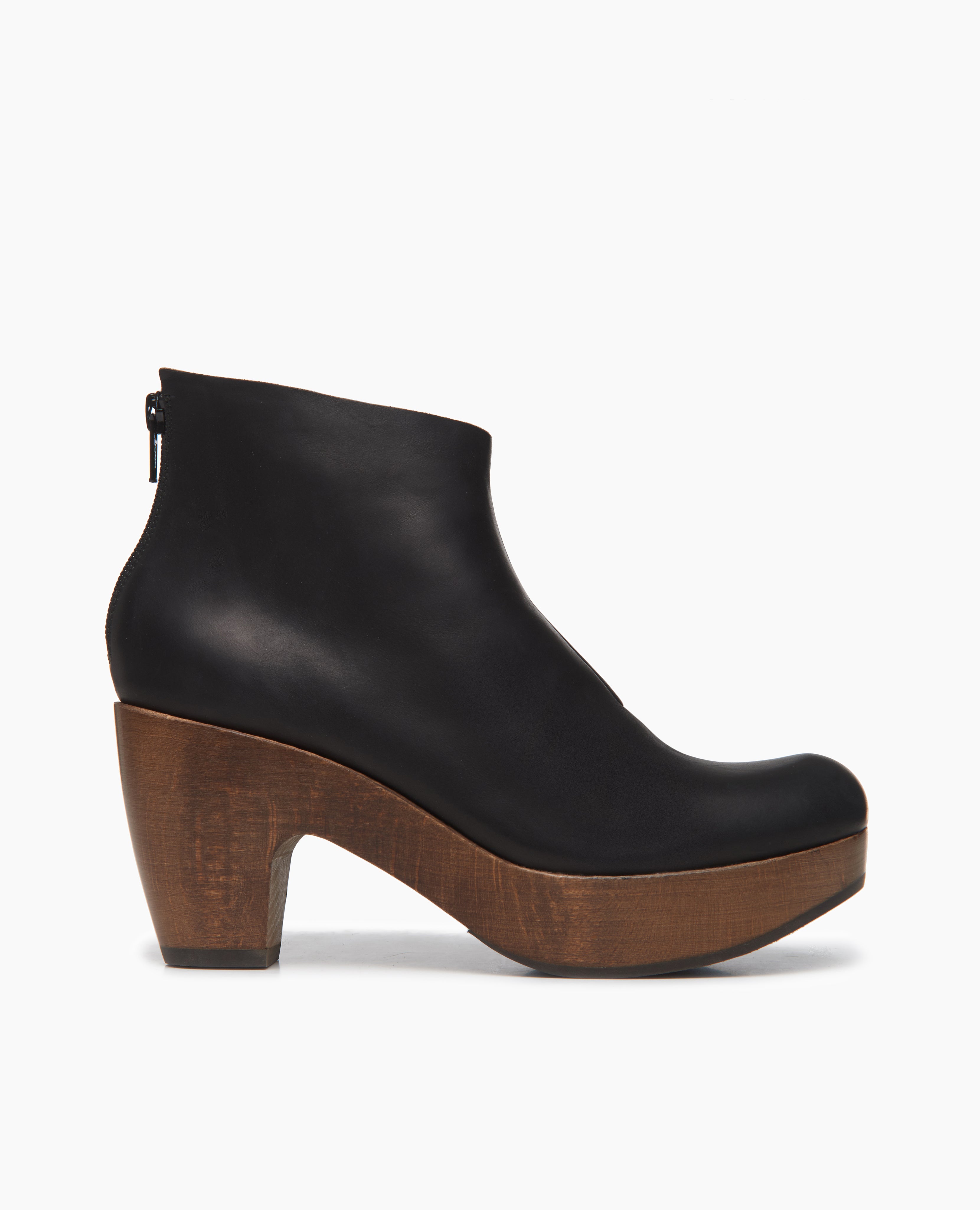 Side view of the Coclico Tik Clog: classic clog bootie with an asymmetrical opening at the ankle for a flattering fit. Back zip closure.