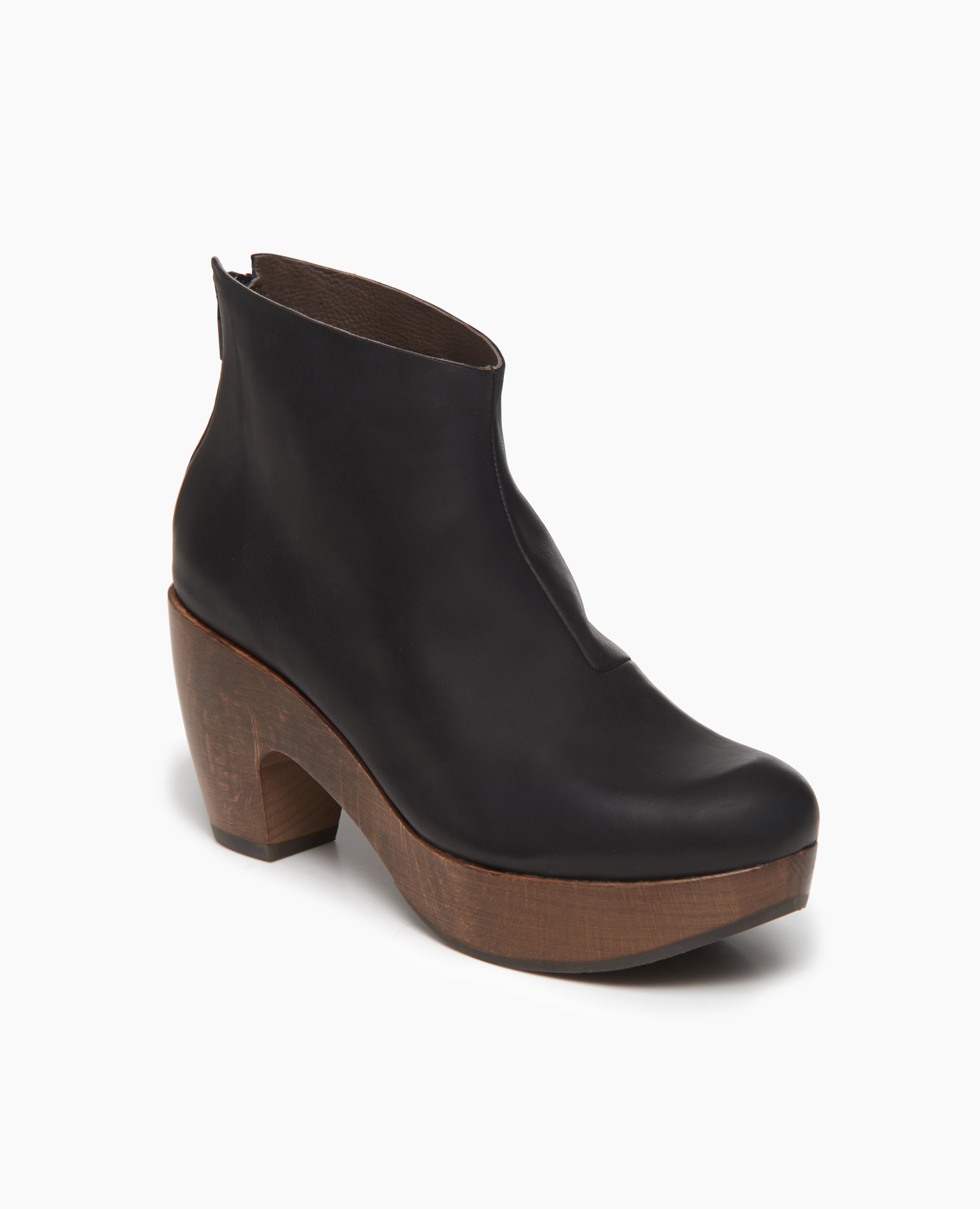 Angled view of the Tik clog: a classic clog bootie faturing an asymmetrical oprning at the ankle for a flattering fit. Back zip closure.