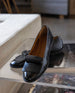 Yale Loafer in Black Patent placed on an acrylic table.  4
