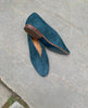 Top view of Coclico Harissa Flat in Bottle suede, a slip-on high vamped flat with a softly rounded toe, leather sole and a 10mm solid wood heel - on stone flooring. 6