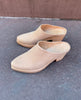 Close up of the Coclico Kule Clog in Latte nubuck: a classic slip-on mule with a tapered toe and mid-height solid wood base - outdoor shot. 1