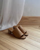 Pair of Coclico Jacque Heel in Mandorla leather a slide-on style with a stretch leather band across foot and a wood block mid-height heel - on wood flooring. 5