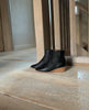 Java Boot in Black placed on the wooden floor near a wooden staircase. 8