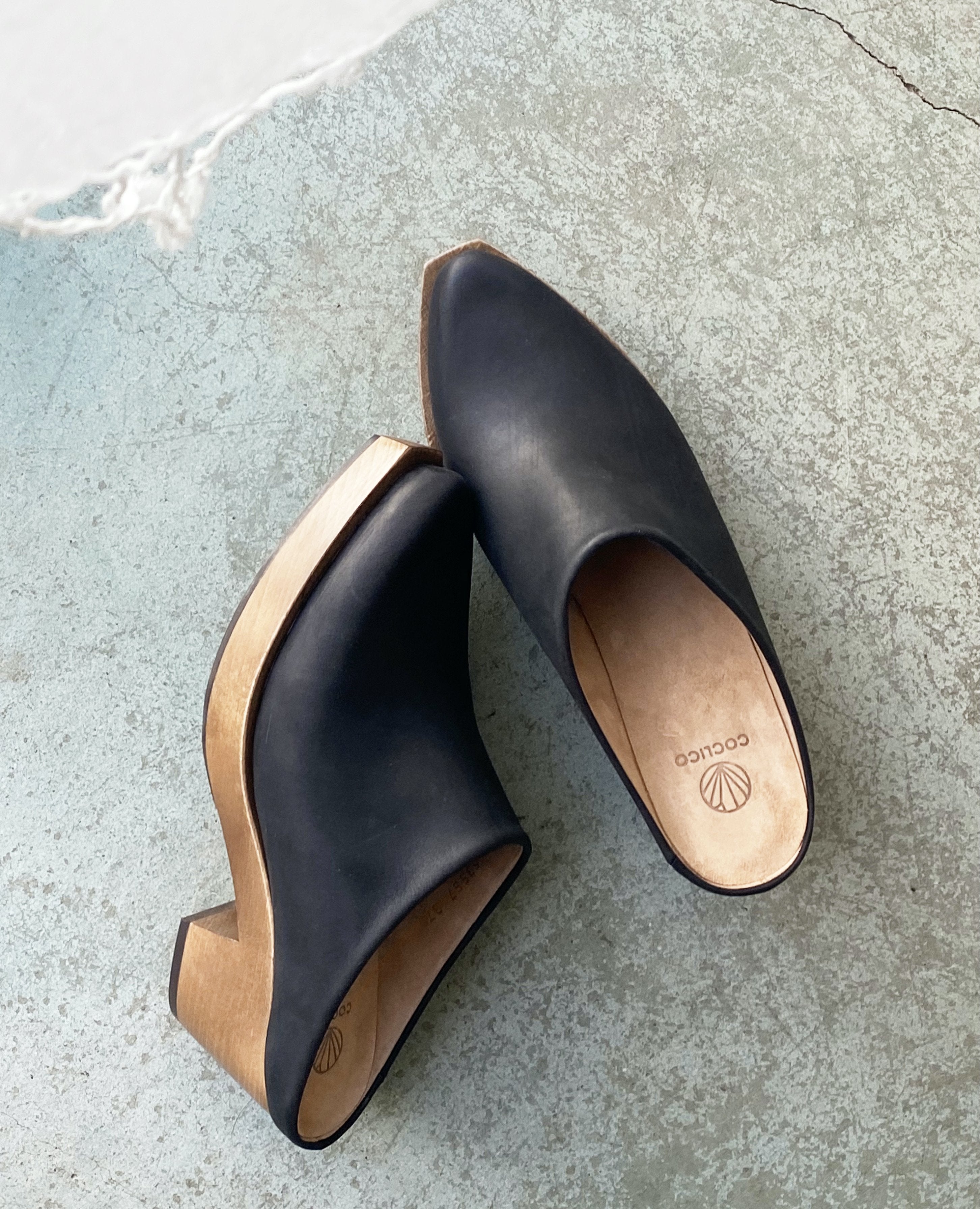 Close up top view of Coclico Kule Clog in Black leather: Slip-on mule, tapered toe, mid-height solid wood base.