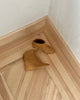A sculpted 75mm solid wood wedge with a rounded toe and a back zip closure - on wood flooring in side, top view. 6