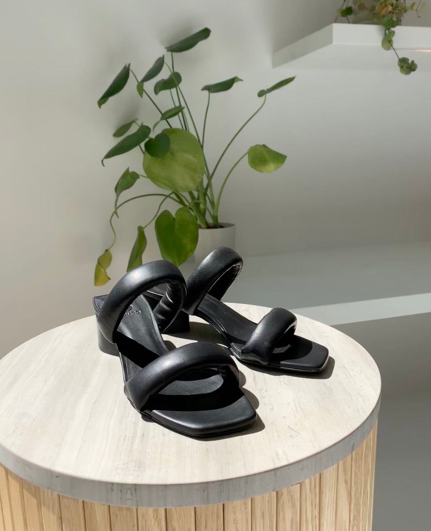 Mid-heel all black slide sandal with two padded straps across the foot.