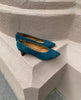 A seasonless slip-on heel with a choked throat line, subtle stichwork and a scultped, oval shaped solid wood heel with a hand-painted chestnut finish - Coclico Wumo Heel displayed on terracotta pillar. 9