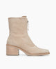 Side view of the Coclico Furin Boot in Latte nubuck, a mid-calf height boot with front zipper closure, leather pull tab, scored rubber sole and a mid-height solid wood block heel. 1
