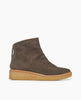 Side view of the Hop Boot in Anthracite suede: a crepe-soled wedge with a .5 inch height, leather welt, natural soft wrinkles and a patinated metal back zipper closure. 1