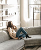 Woman modeling the Coclico Ruba Clog in Black leather - model seated on grey couch. 5