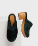 Dark green, plush fur clogs with a wooden sole and block heel, featuring a smooth, rounded toe and a branded insole. 1