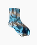 A pair of mid-calf socks featuring a tie-dye pattern in shades of blue, brown, and white, with a ribbed texture and a soft, stretchy fabric. 2