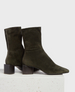 A pair of dark olive green suede ankle boots with a pointed toe, side zipper, and a chunky, low block heel. 1