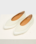 A pair of sleek, cream-colored slip-on shoes with a pointed toe, smooth leather texture, and a contrasting white sole, featuring a minimalist design and tan interior lining. 1