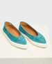 A pair of teal suede slip-on shoes with a smooth texture, featuring a pointed toe design and a contrasting white rubber sole. 1