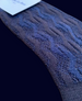 A textured, dark blue knitted fabric with a wavy pattern, appearing soft and flexible, likely made of wool or a similar material, and featuring a rectangular shape. 4