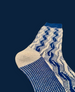 A single sock featuring a blue and white zigzag pattern, with a solid blue toe and heel, and a textured knit material. 5